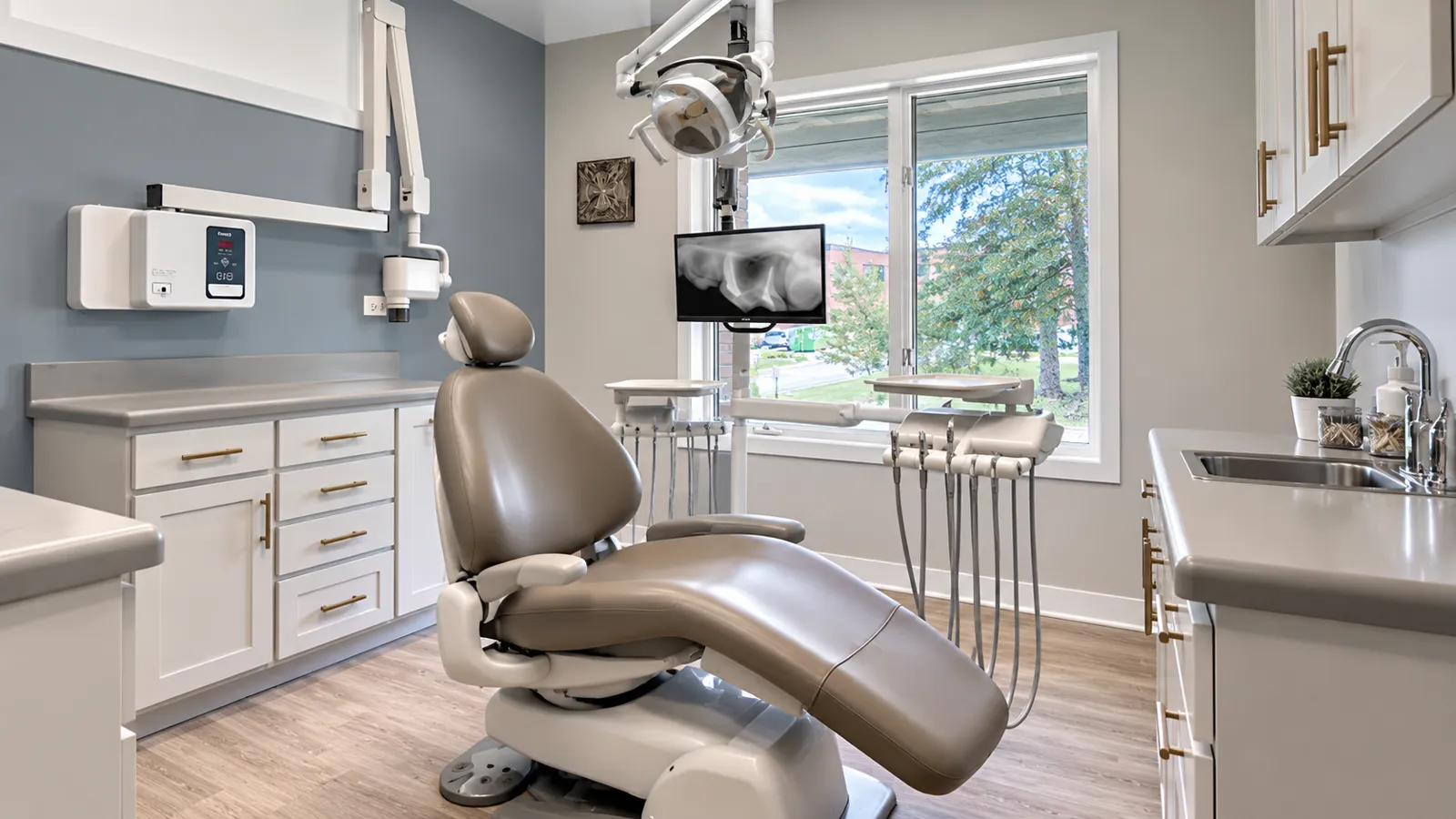 A treatment room at Renew Dental Loft with a blue accent wall and a dental chair facing the window