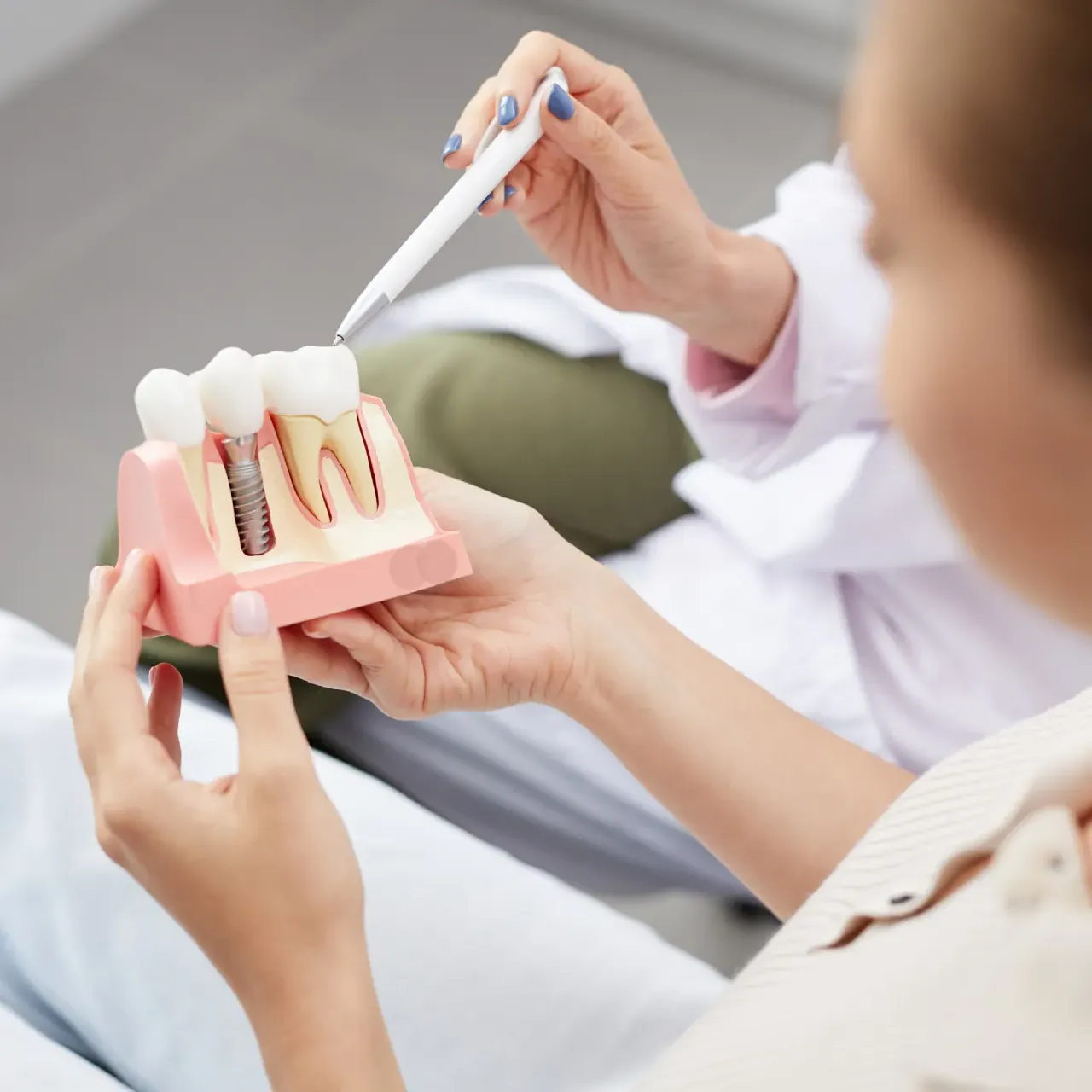 Dr. Hays pointing at some dental implants